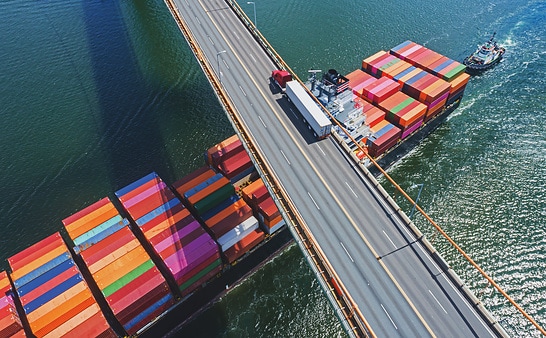 Brücke mit LKW und Cotainer-Schiff